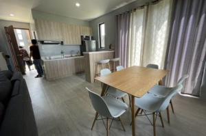 a kitchen with a wooden table and white chairs at house luxury vip in Balayan