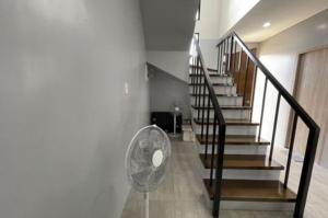 a room with a staircase with a fan and a stair case at house luxury vip in Balayan