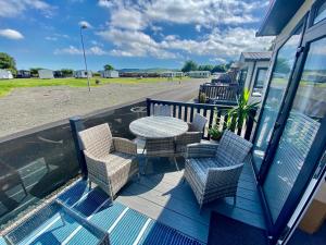 a patio with a table and chairs on a balcony at Debran Lodge in Angus