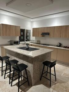 a kitchen with a large island with chairs around it at Rachos in Oujda