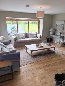 a living room with two couches and a coffee table at Murreigh Beag Waterville in Waterville +1 photo