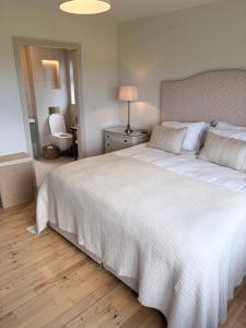 a bedroom with a large bed with a white bedspread at Murreigh Beag Waterville in Waterville