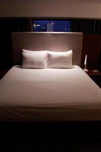 a large white bed with two pillows and a window at Casahindout in Hanoi