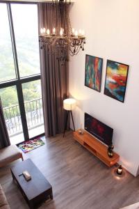 a living room with a chandelier and a large window at Casahindout in Hanoi