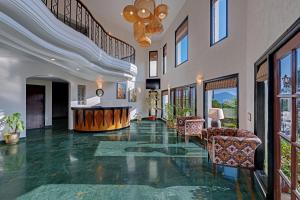 ein großes Wohnzimmer mit Stühlen und einer Decke in der Unterkunft 8fold-Pinecrest By LaRiSa, Bhimtal in Bhīm Tāl