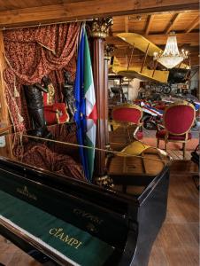 a piano in a room with a table and chairs at Hotel Chopin in Fiumicino