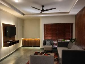 a living room with a couch and a ceiling fan at The Elet Express Luxury Hotel Apartments in Karachi