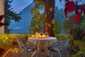 ein Tisch mit zwei Stühlen und Kerzen darauf in der Unterkunft 8fold-Pinecrest By LaRiSa, Bhimtal in Bhīm Tāl