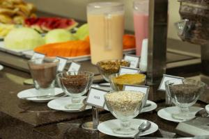 a bunch of glasses filled with food on a counter at Umbu Hotel Porto Alegre - Centro Histórico - Prox Aeroporto in Porto Alegre