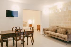 a living room with a couch and a table and chairs at Treviè Suite - Torre San Giovanni in Fontanelle
