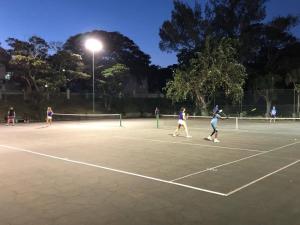 a group of people playing tennis on a tennis court at Moxley Manor in Durban