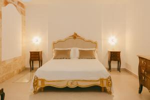 a bedroom with a bed with two nightstands and two tables at Treviè Suite - Torre San Giovanni in Fontanelle