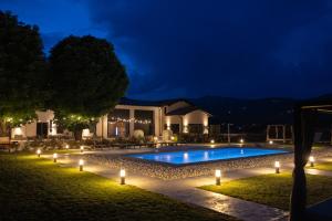a swimming pool with lights in a yard at night at GardaZen Suites - luxury - adults only in Caprino Veronese