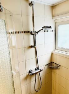 a shower in a bathroom with a shower head at Chalet op de veluwe in Putten +31 photos