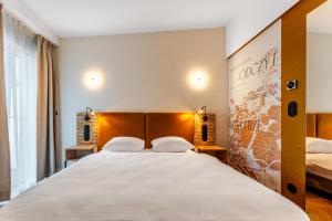 a bedroom with a large white bed with two pillows at Art Queen Aparthotel in Krakow +29 photos