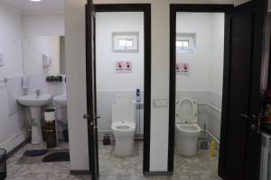 a bathroom with two toilets and a sink at Bulak - Kyrgyz Family Hostel in Karakol