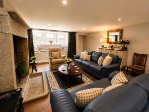a living room with a blue couch and a fireplace at The Bronte Moor Retreat - 3 Bed, Pet Friendly Cottage - Stunning Views - Hot Tub in Heptonstall
