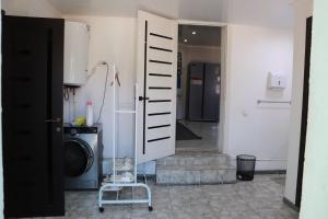a laundry room with a washing machine and a door at Bulak - Kyrgyz Family Hostel in Karakol +32 photos