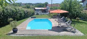 a swimming pool with a deck and an umbrella at Chambre d'hôtes Bidegaina in Ahetze