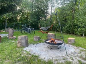 a fire pit in a yard with a hammock and a bike at Slow Flow Glamp - sauna, basen i jacuzzi in Rzyki