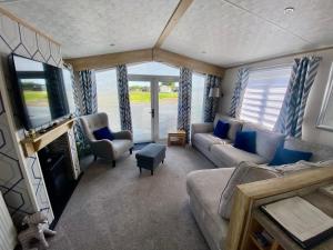 a living room with a couch and a tv at Debran Lodge in Angus