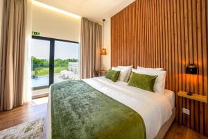 a bedroom with a large bed and a large window at Moinho do Canto Residence Hotel in Rio Maior +21 photos