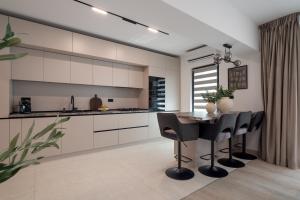 a kitchen with white cabinets and a table and chairs at Celeste Apartment 2BDR Parking in Bucharest +75 photos