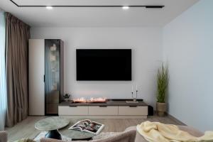 a living room with a tv on a white wall at Celeste Apartment 2BDR Parking in Bucharest