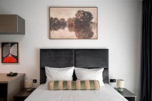 a bedroom with a bed with a black headboard at Celeste Apartment 2BDR Parking in Bucharest