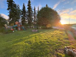 a yard with a playground with the sunset in the background at Anchorage Fireoved Home Theater Experience in Anchorage