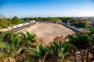 an aerial view of a large empty field with palm trees at Hotel Caminho do Rosário in Aparecida