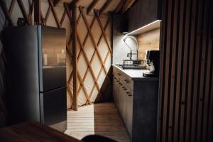 a kitchen with a stainless steel refrigerator in a room at Slow Flow Glamp - sauna, basen i jacuzzi in Rzyki +25 photos