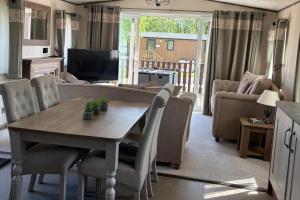 a living room with a table and a couch at 2-Bed Cabin - Sleeps 5 - Parking - Pet Friendly in Carnforth