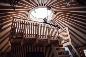 a round window in a cabin with a wooden ceiling at Slow Flow Glamp - sauna, basen i jacuzzi in Rzyki