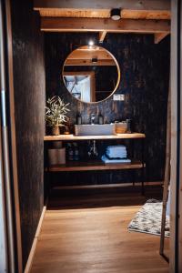 a bathroom with a sink and a mirror at Slow Flow Glamp - sauna, basen i jacuzzi in Rzyki