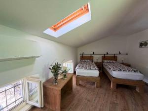 a bedroom with two beds and a skylight at Agriturismo Fruske in Aurisina