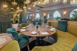 a restaurant with a wooden table and green chairs at The Marine Hermanus in Hermanus