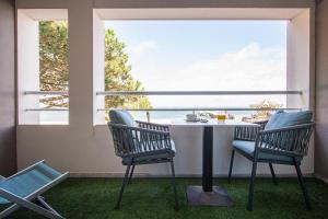 a balcony with a table and chairs and a view of the ocean at Hôtel Le B d'Arcachon by Inwood Hotels in Arcachon
