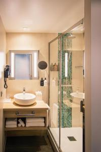 a bathroom with a sink and a shower at Hôtel Le B d'Arcachon by Inwood Hotels in Arcachon