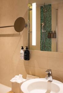 a bathroom with a sink and a mirror at Hôtel Le B d'Arcachon by Inwood Hotels in Arcachon +36 photos