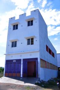 a white building with a garage at Dharani Residency in Pondicherry
