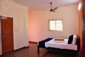 a bedroom with a bed and a window at Dharani Residency in Pondicherry