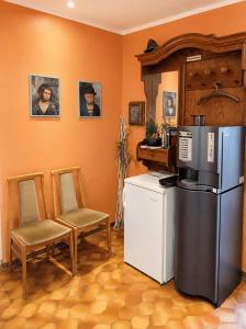 a kitchen with a refrigerator and a table and chairs at Pension Greifswald in Dargelin