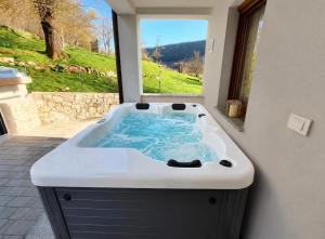 a bath tub with a view of a window at Holiday House Marija in Otočac