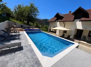 a swimming pool in the backyard of a house at Holiday House Marija in Otočac