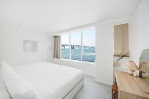 a white bedroom with a view of the water at 지니스테이 in Millak-tong +29 photos