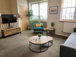 a living room with a couch and a tv and a table at Southcourt in Worthing
