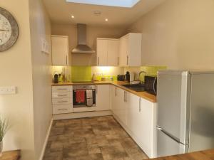 a kitchen with white cabinets and a refrigerator at Southcourt in Worthing