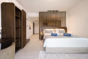 a bedroom with a large bed with white sheets and pillows at Avenue by Deserve in Paphos +18 photos