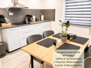 a kitchen with a wooden table and chairs at Stierpartment am Pfälzer Wald nähe Outlet Center Zweibrücken in Pirmasens